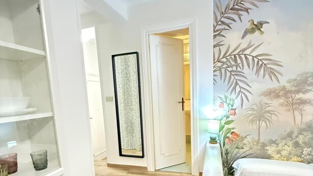 A bedroom with a bed, a nightstand, and a wall mural. There is a staircase leading to another room. - Best Bnb Alfieri (Florence)