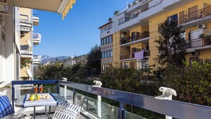 A balcony with a table, chairs, and a view of surrounding buildings and greenery. - Marescala vacation - Doria Home, spacious apartment in Sorrento town. (Sorrento)
