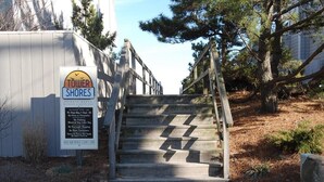 A wooden staircase leading to a building with a sign that reads "TOWER SHORES" and lists various rules and regulations. - Spacious 4BR Townhome near the Ocean (North Bethany Beach)