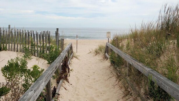 A sandy beach path with wooden railings and a signpost. - Spacious 4BR Townhome near the Ocean (North Bethany Beach)