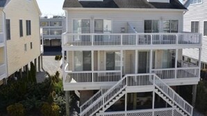 A two-story house with a balcony on the second floor. - Spacious 4BR Townhome near the Ocean (North Bethany Beach)