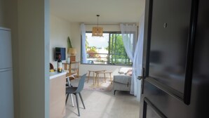 Een knus woongedeelte met een kitchenette, een eetruimte en een zithoek met uitzicht op het groen.