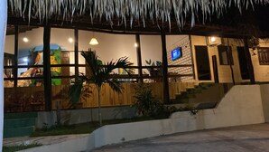 A building with large windows, a staircase, and a TV screen. - Pousada Muretá  (Santarém)