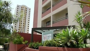 A multi-story building with balconies and a sign that reads "Oñieca Flat." - Ômega Flat (Bauru)