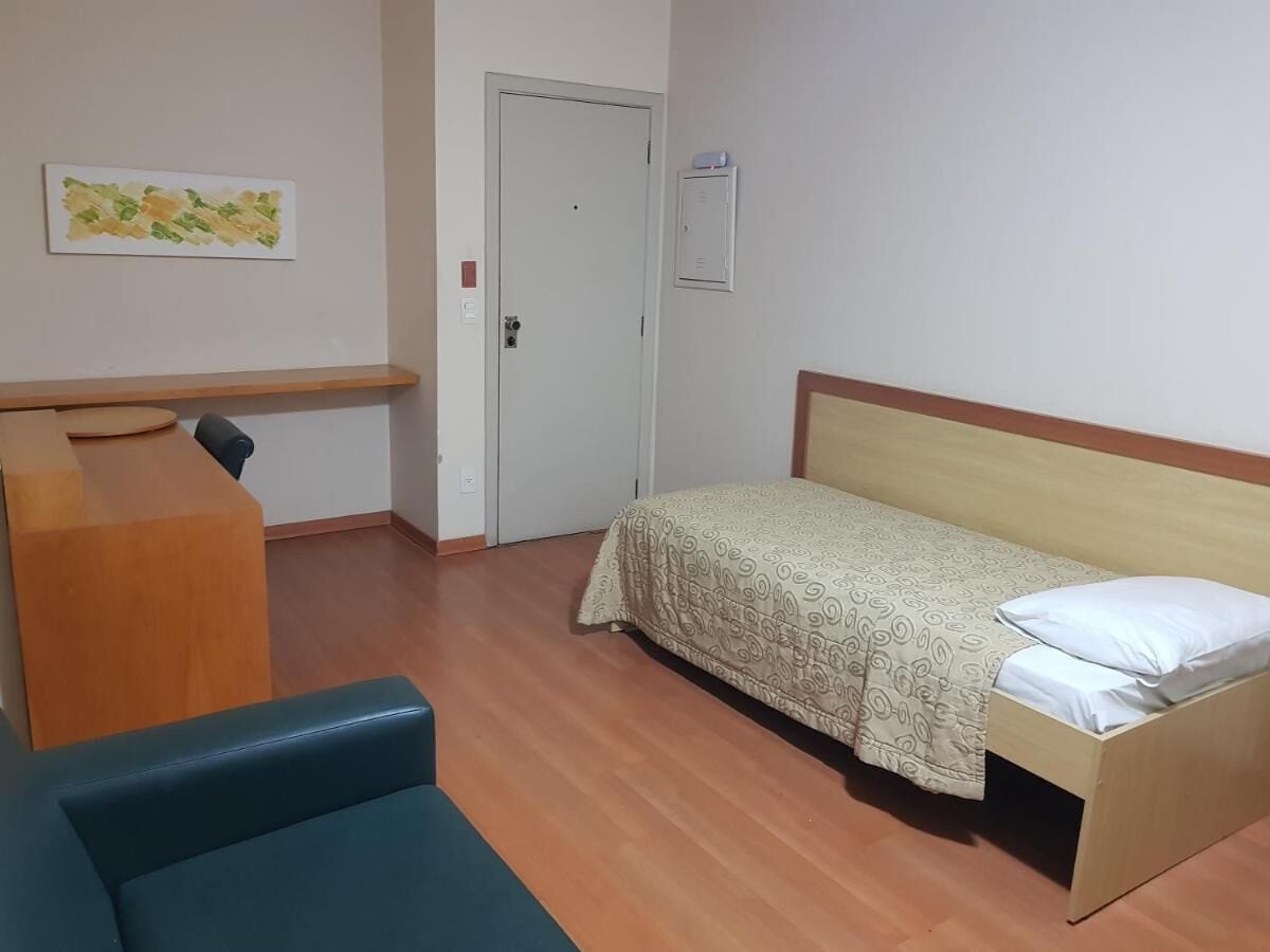 A room with a bed, a desk, and a chair.