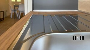 Une cuisine moderne dotée d’un four encastré et d’un plan de travail en bois.