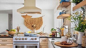 Une cuisine moderne équipée d’une cuisinière, d’un four et de divers ustensiles de cuisine disposés sur le plan de travail.
