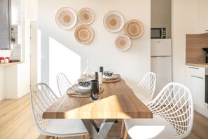 Enjoy meals in this dining area with a table for four, a microwave nearby, and a stylish arrangement of wall hangings.