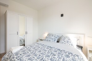 Cozy retreat with a large bed, wardrobe, and bedside table.