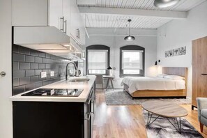 Un appartement compact comprenant un coin cuisine, un lit et un espace repas.