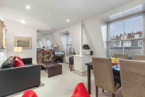 Een moderne woonkamer met een bank, salontafel en een eethoek.