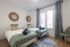 A hotel room with two beds, a large window with curtains, a chair, and two wall-mounted mirrors. - Marbella Old Town Apartmet with Parking (Marbella)