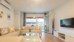 Una sala de estar moderna con un sofá, una mesa de centro y un televisor de pantalla plana.