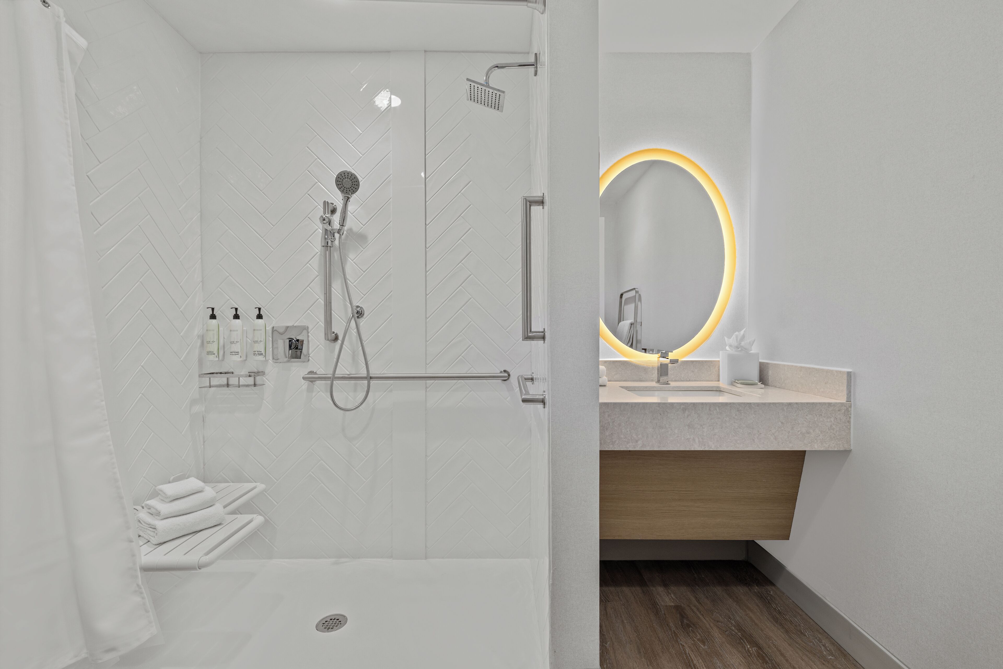 A modern bathroom with a shower, toilet, and sink.