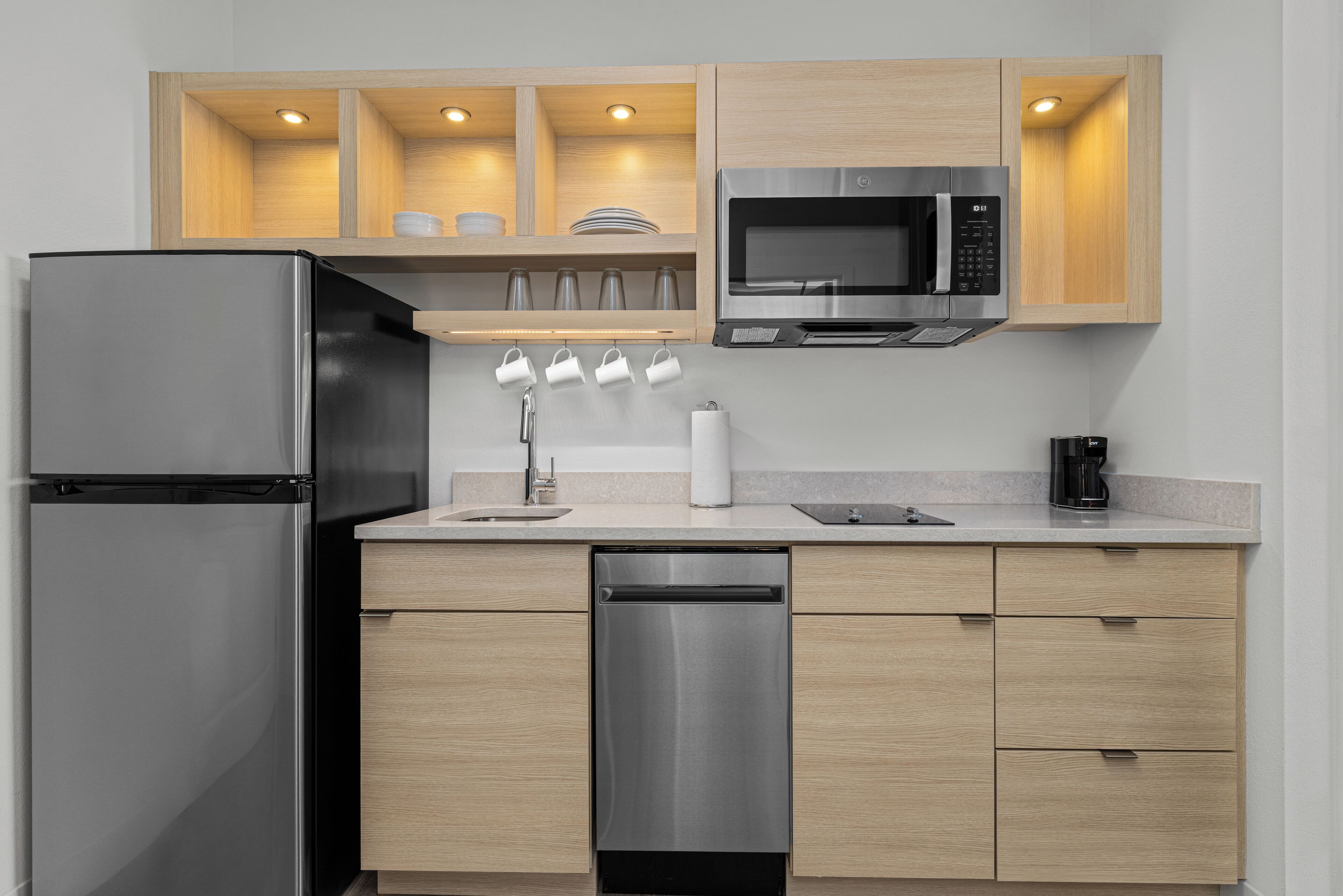 A modern kitchen with a stainless steel refrigerator, microwave, and dishwasher.