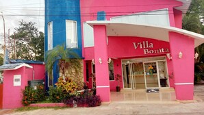 Un edificio de color rosa y azul con un letrero que dice "Villa Bonita".