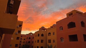 A row of buildings with flat roofs and multiple windows, likely part of a hotel or residential complex. - Home from home 1 bedroom apartment with AC & WiFi in fantastic Al dora compound (Red Sea Governorate)