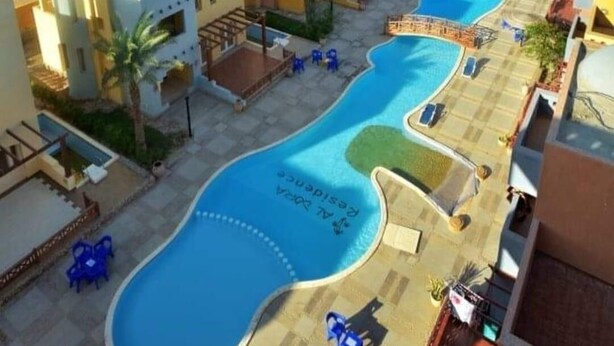A resort with multiple swimming pools, a beach, and buildings with balconies. - Home from home 1 bedroom apartment with AC & WiFi in fantastic Al dora compound (Red Sea Governorate)