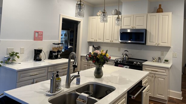 A modern kitchen with white cabinetry, stainless steel appliances, and pendant lighting. - Charming Masters Rental: 5BR Home Near Augusta National (Martinez)
