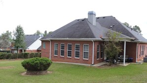 A two-story brick house with a gabled roof, a covered porch, and a well-maintained lawn. - Charming Masters Rental: 5BR Home Near Augusta National (Martinez)