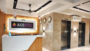 A reception desk with a sign reading "ACEOTEL" and two elevators. - Aceotel Premier TK Morbi (Morbi)