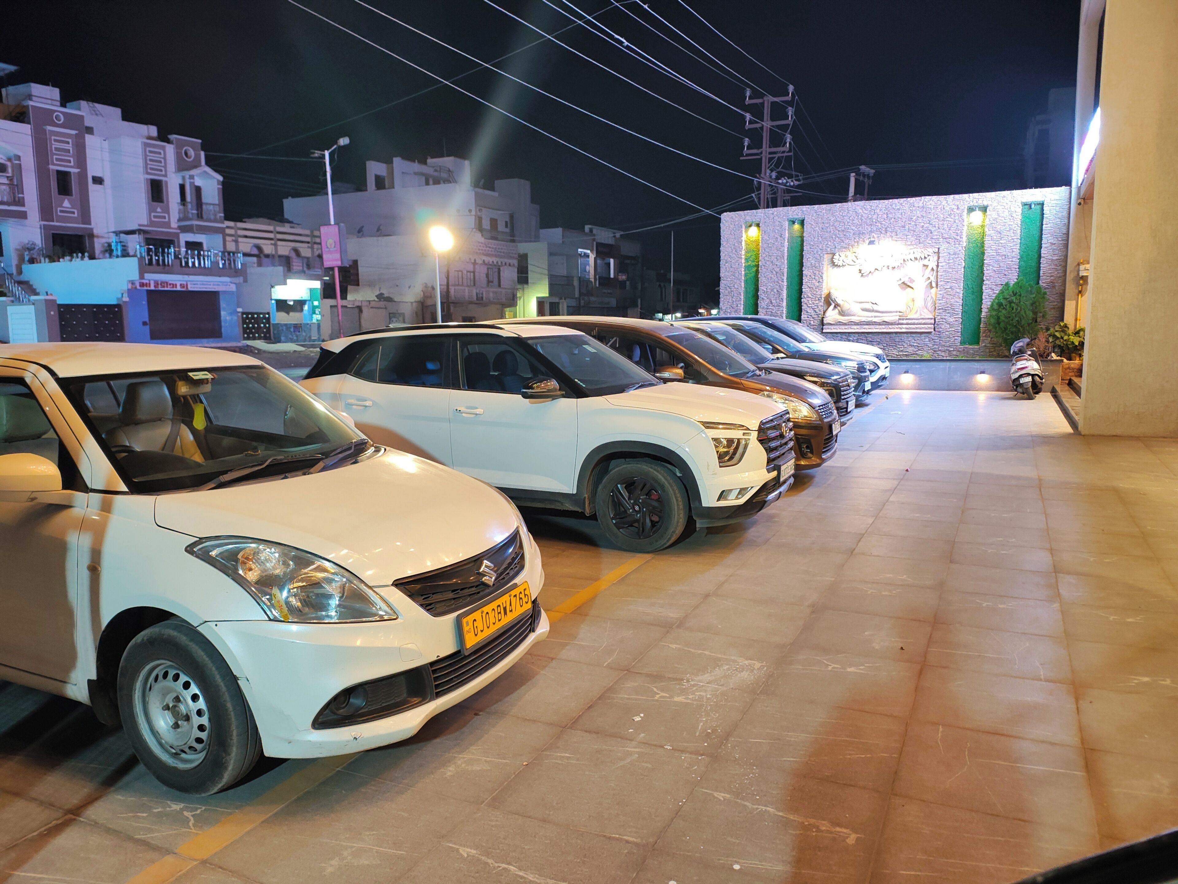 A row of parked cars in a parking lot at night.