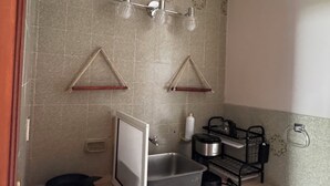 Una cocina compacta con un lavamanos, estufa y encimera.