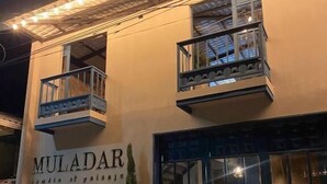 Un edificio con un cartel que dice "MULADAR" y un balcón.