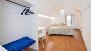 Un dormitorio con una cama, un escritorio y una silla.