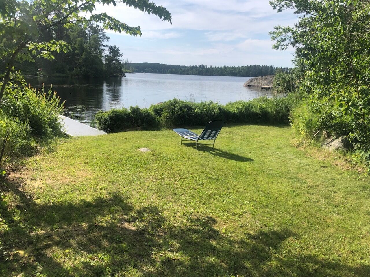 Un espace verdoyant avec un banc et une vue sur le lac.