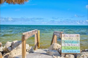A wooden sign with directions to various locations by the water. - Key Largo Escape: Pool, Pickleball & Marina! (Key Largo)