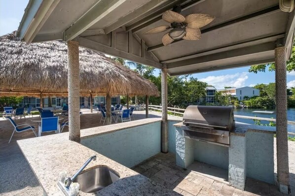 An outdoor patio with a grill, seating area, and a pool view. - Key Largo Escape: Pool, Pickleball & Marina! (Key Largo)