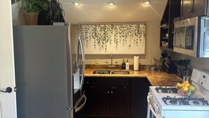 Eine moderne Küche mit Kühlschrank, Herd, Spüle und Arbeitsplatte.