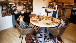 Un comedor con una mesa redonda, sillas y una barra libre.