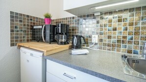 A compact kitchen with a coffee maker, a toaster, and a sink.