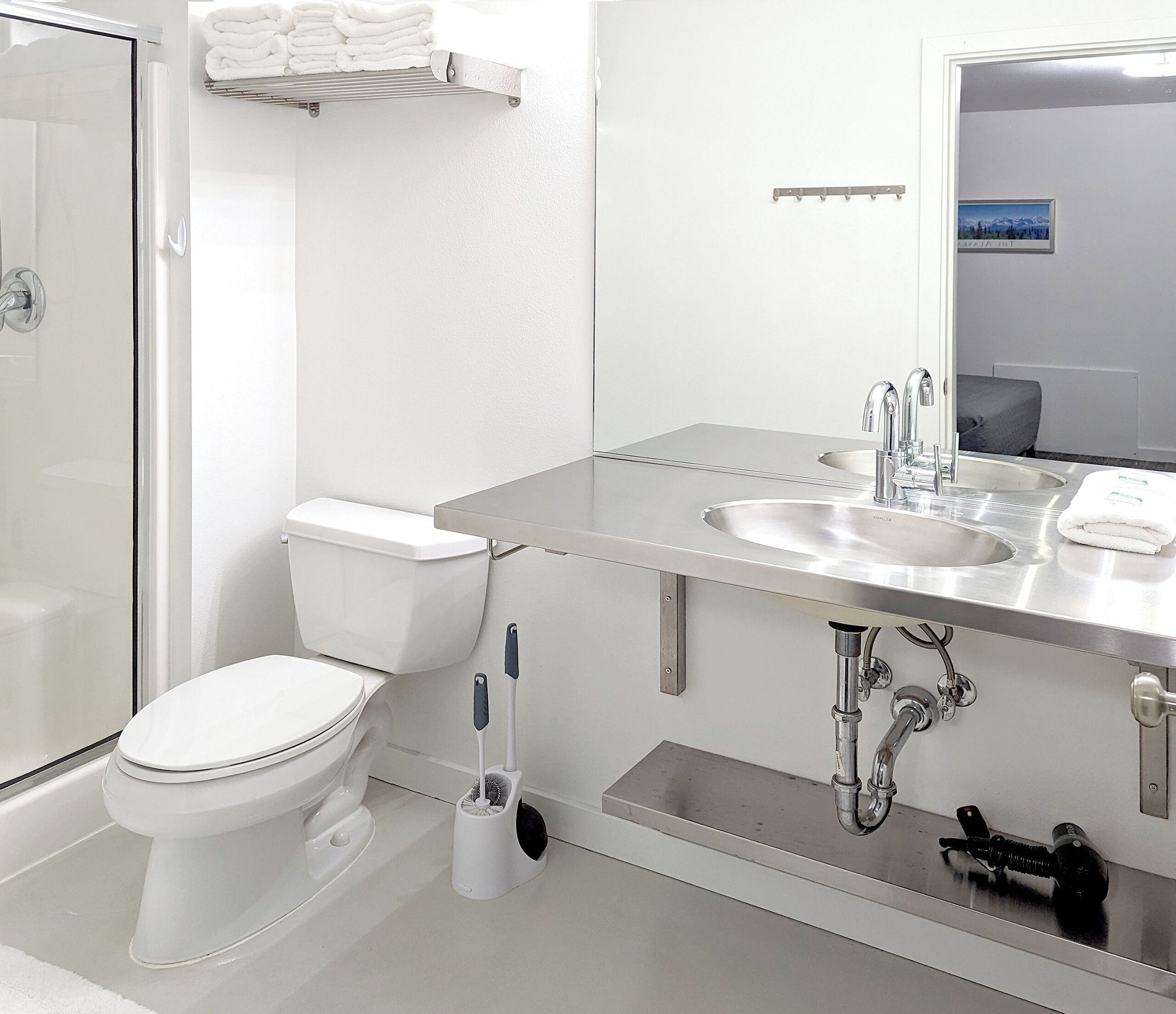 Un baño moderno con inodoro, lavamanos y ducha.