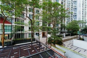 Ein mehrgeschossiges Wohngebäude mit Balkonen, Grünflächen und modernem architektonischen Design.