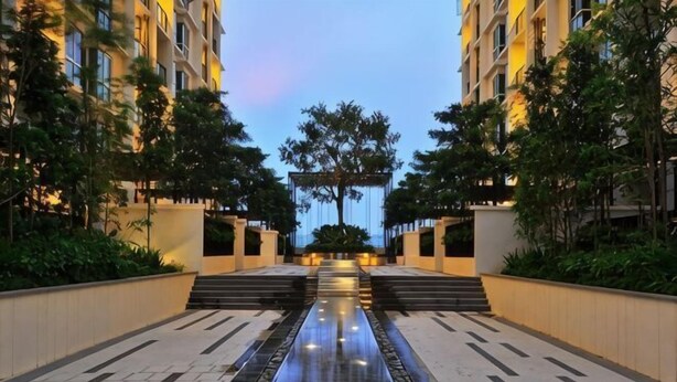 A modern building with a central water feature, surrounded by greenery and a well-lit pathway. - Shore Hotel Melaka Private Suites (Melaka)