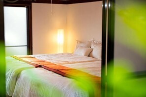 A hotel room with a bed, a bedside lamp, and a window. - Awaji Seaside Hotel in Ikuho (Awaji City)