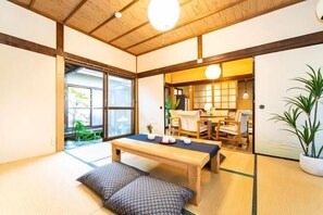 A traditional Japanese room with tatami flooring, a low wooden table, and a sliding door leading to another room. - Awaji Seaside Hotel in Ikuho (Awaji City)