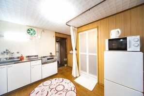 A compact kitchen with white cabinets, a microwave, and a sink. - Awaji Seaside Hotel in Ikuho (Awaji City)