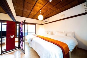 Una habitación de hotel con una cama grande, una cortina roja y un techo de madera.