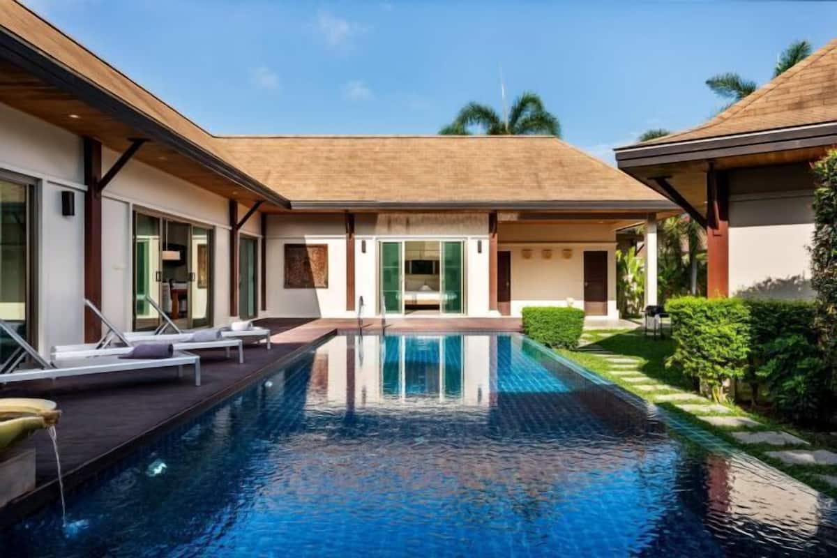 A modern house with a swimming pool, large windows, and a covered patio area.