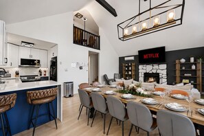 A modern kitchen with a dining area, a fireplace, and a Netflix sign.
