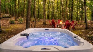 A hot tub in a forest with red chairs and a fire. - Cozy Forest Retreat with Hot Tub, Sauna, Pool (East Stroudsburg)