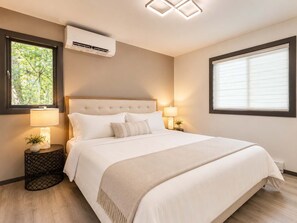 Een slaapkamer met een bed, twee nachtkastjes, een raam, een airconditioner en een plafondlamp.