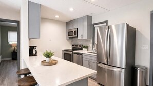 A modern kitchen with a large island, stainless steel appliances, and a minimalist design.