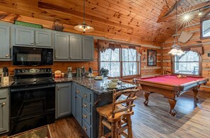 A log cabin interior with a kitchen, dining area, and pool table. - Cherokee Lodge-Pet Friendly, Luxury Log Cabin Rental, Hot Tub, 2 Fireplaces, Fishing- Nantahala NC. (Topton)