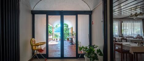 A hotel lobby with a view of an outdoor patio area.