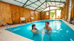 Una piscina interior con paredes de madera y techo de metal.